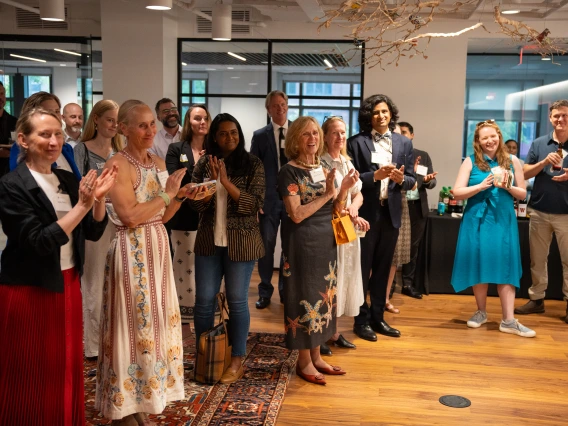 A crowd in formal dress applaud. 
