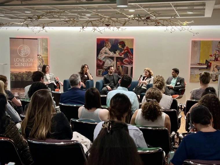 Looking across a seated crowd at a panel discussion.