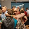 Two women embrace in a crowd.
